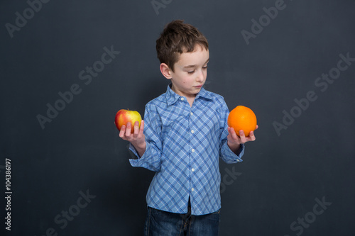 break for fruits, boy holding apple and orange
