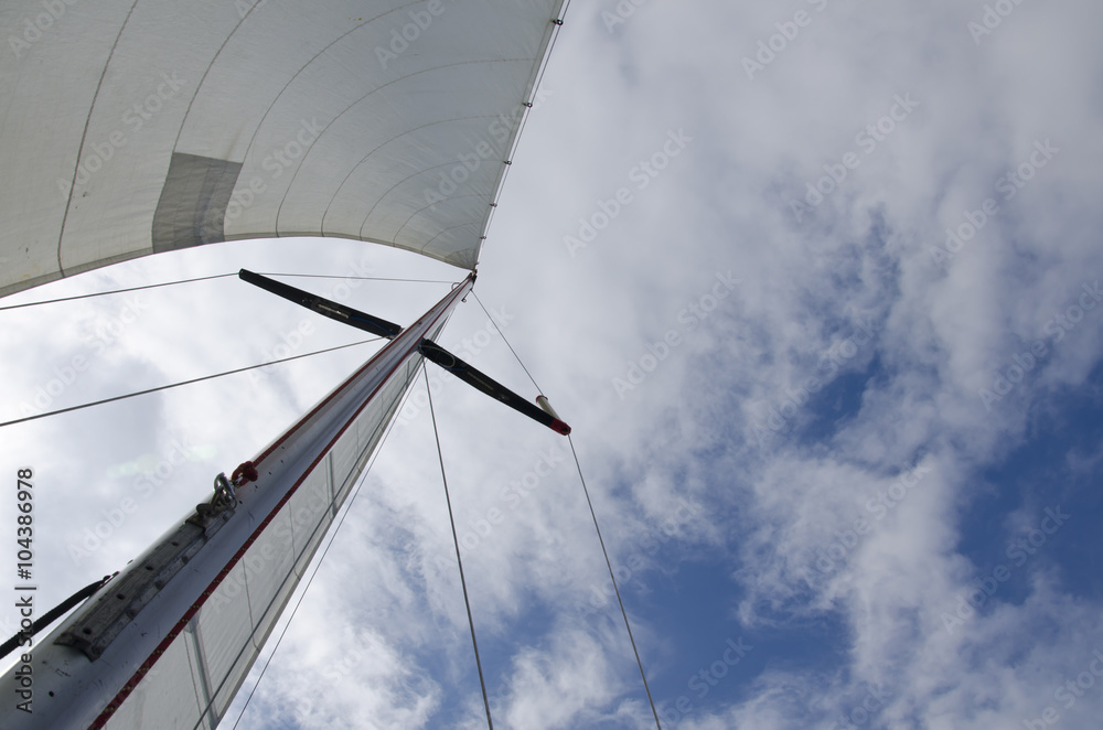 Big white sail of a sailing yacht against the sky
