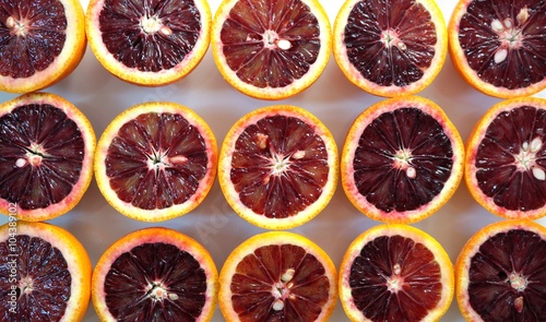 Ruby red blood oranges cut in half on a white platter