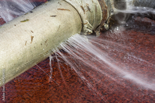 water leaking from hole in a hose photo