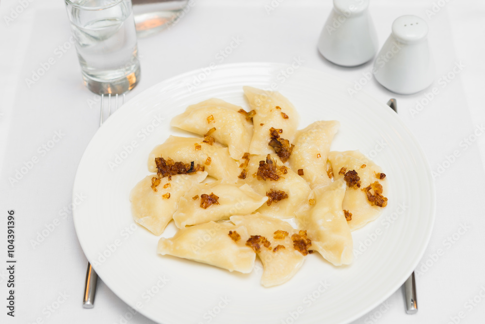 Russian dumplings with fried onion on white plate Russian dumplings with fried onion on white plate