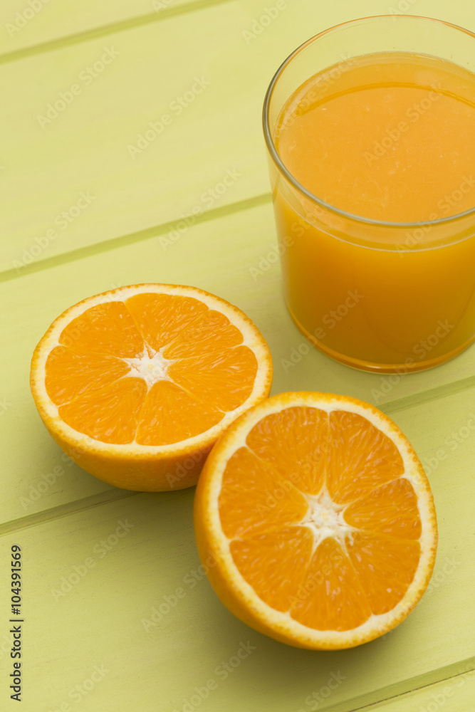 Orange juice and slices of orange on green table Orange juice and slices of orange on green table