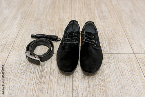 black bow tie and leather shoes groom lying next to belt of trousers. Groom accessories, businessman, 