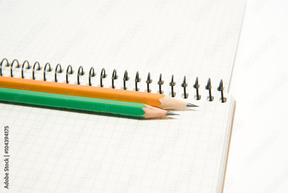 Opened notebook and pencils on over white Opened notebook and pencils on over white