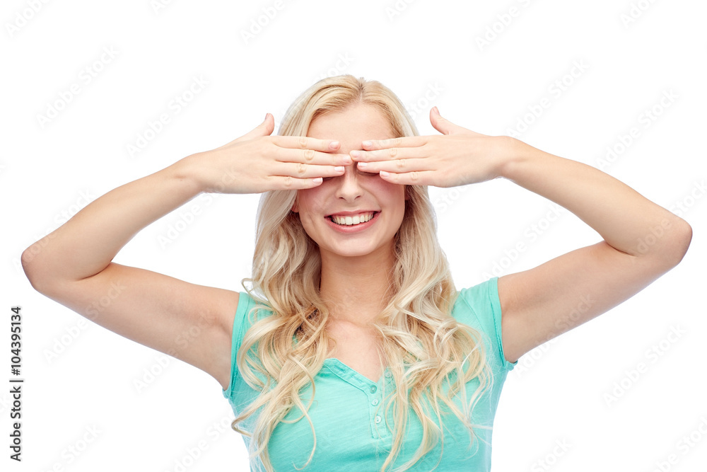 smiling young woman or teen girl covering her eyes smiling young woman or teen girl covering her eyes