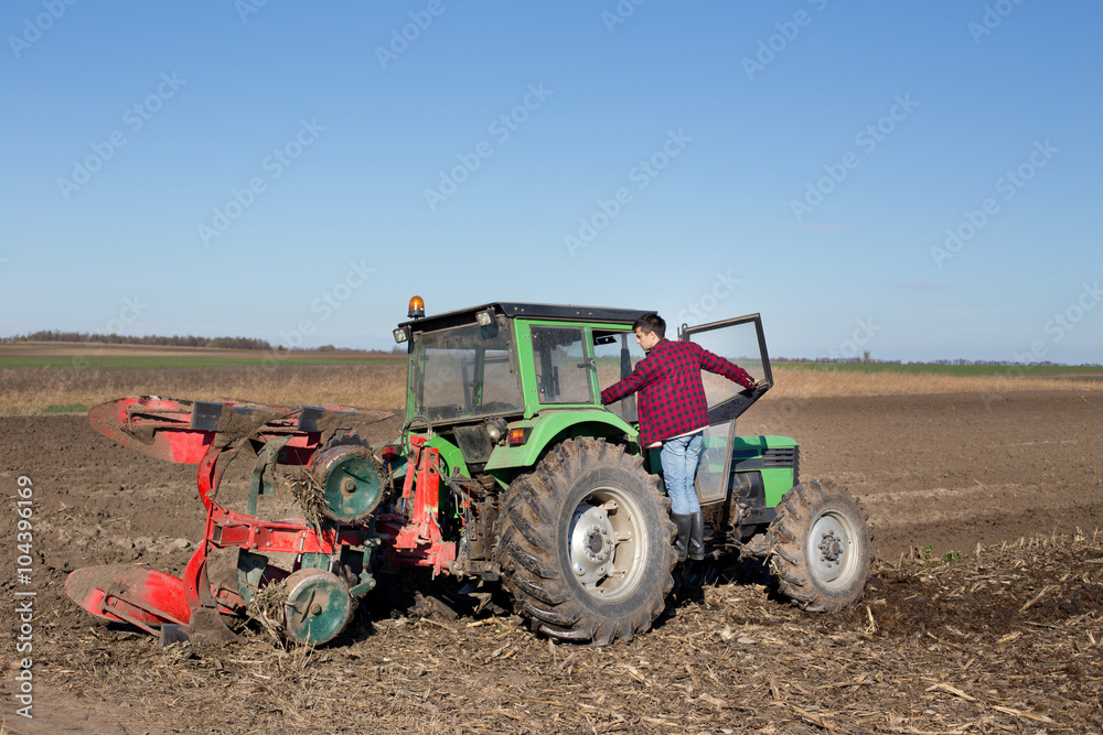 Obraz premium Farmer climbing on tractor
