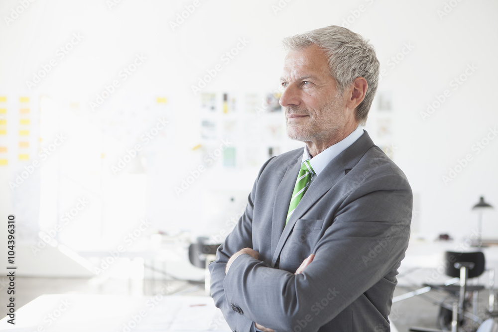 Confident businessman in office thinking