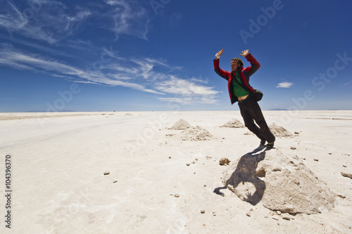 young man jumping from salt heap at Salar Uyuni, Bolivia