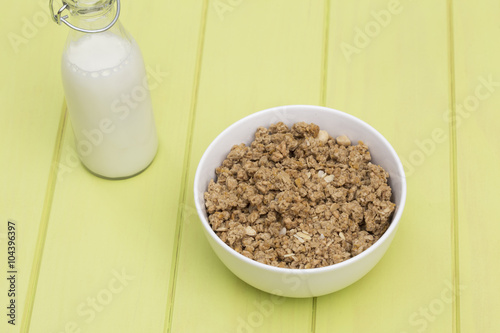 Granola in a bowl with milk on a wooden table, muesli © Antonio Ovejero Diaz