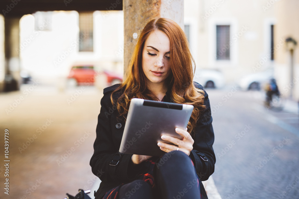 Young woman looking at digital tablet outdoors Young woman looking at digital tablet outdoors