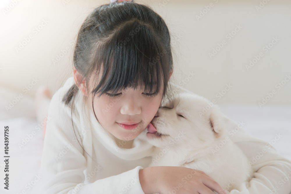 puppy is lovingly licking the cheek of a asian girl. puppy is lovingly licking the cheek of a asian girl.