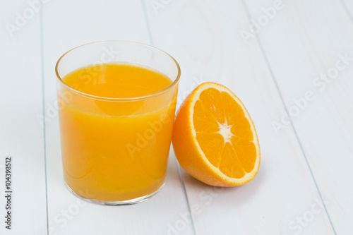 Orange juice and slices of orange on blue table