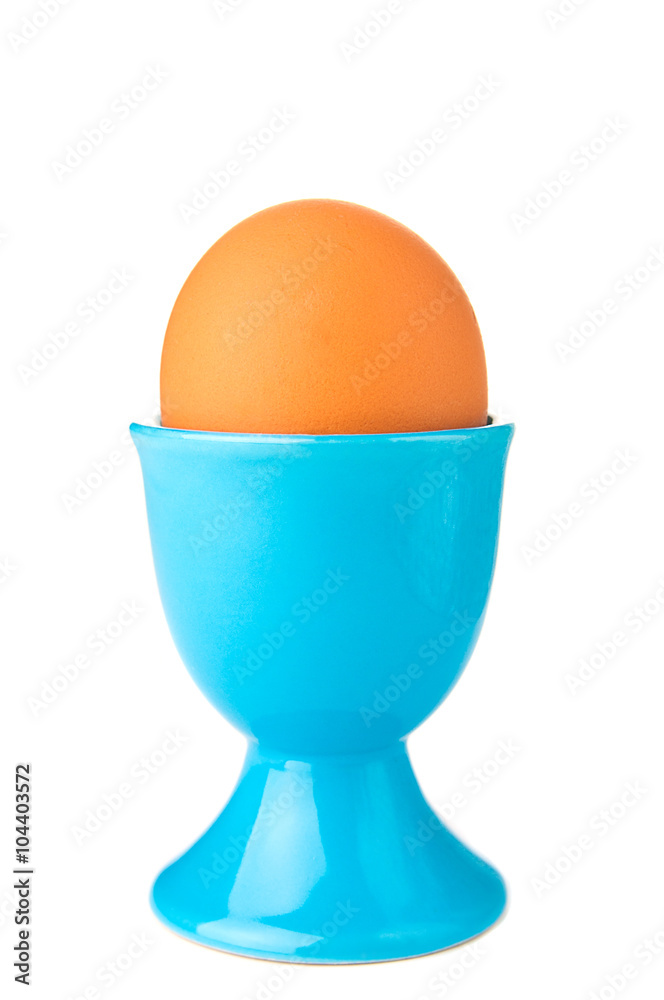 Egg in blue egg cup isolated on white Egg in blue egg cup isolated on white