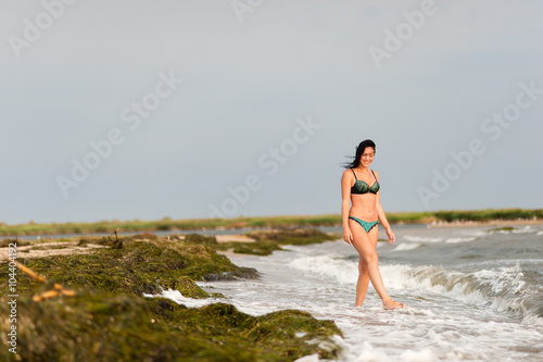 Beautiful girl sunbathing and swimming in the sea