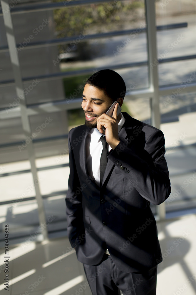 Young black man with telephone in the office Young black man with telephone in the office