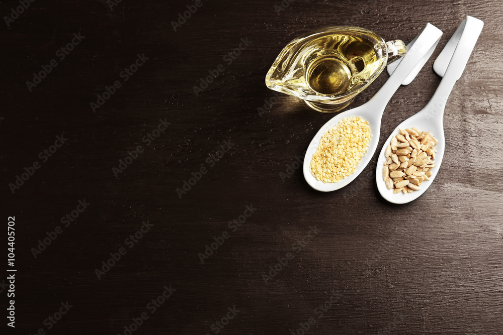 Sunflower and sesame seeds with oil on wooden table Sunflower and sesame seeds with oil on wooden table