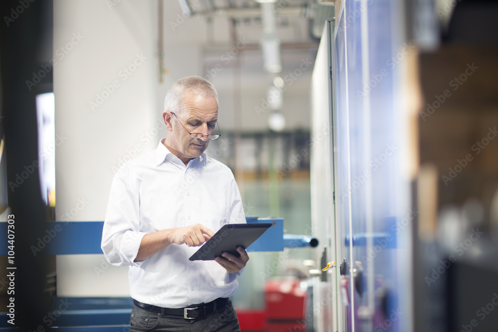 Engineer with digital tablet controlling industrial plant Engineer with digital tablet controlling industrial plant