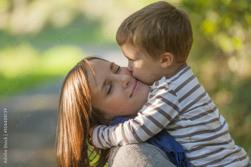 Little boy hugging and kissing his happy mother Little boy hugging and kissing his happy mother
