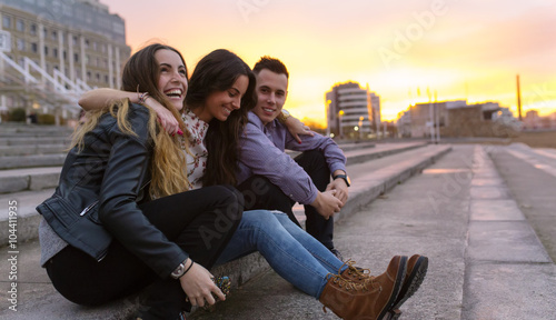 Three friends having fun together at sunset