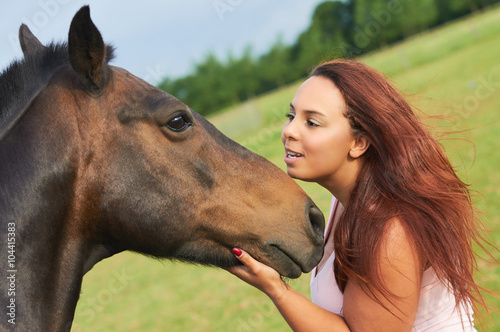 Unique portrait of curly girl loving and hugging her horse © sebastiangora