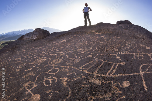 Hiker admires native american rock art. photo