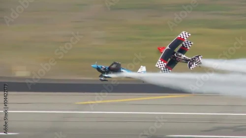 Two biplanes perform a dangerous stunt at an airshow.