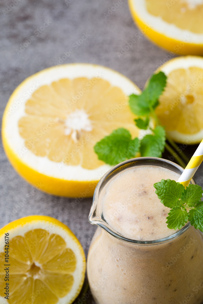Banana and lemon smoothie, on the grey background. Banana and lemon smoothie, on the grey background.