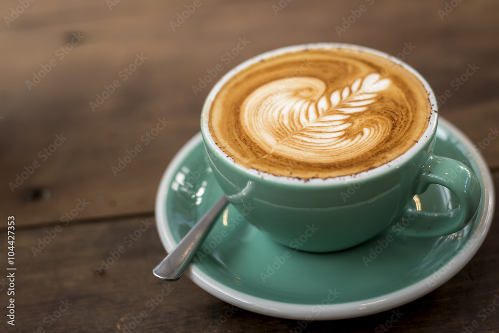 hot cappuccino with latte art on wood background hot cappuccino with latte art on wood background