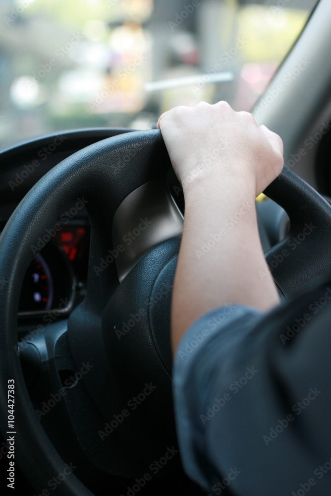 Man driving car with his hand on the steering wheel, in Thailand
