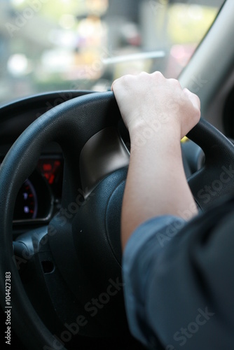 Man driving car with his hand on the steering wheel, in Thailand
