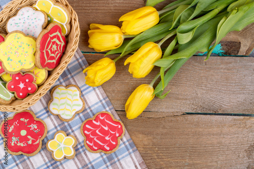 Homemade baked gingerbread and tulips on wooden table