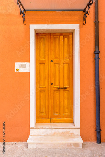 Entrance of a colorful apartment building in Burano, Venice, Italy.