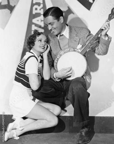Man playing banjo for adoring woman 