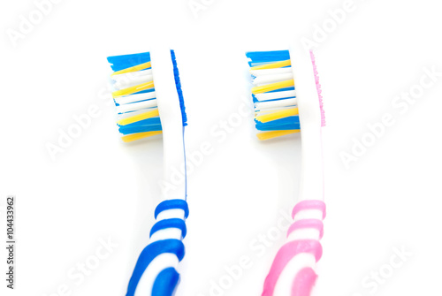 pink and blue toothbrushes on white