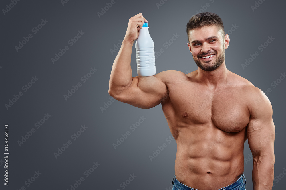 Fototapeta premium Athletic Man Fitness Model holding bottle