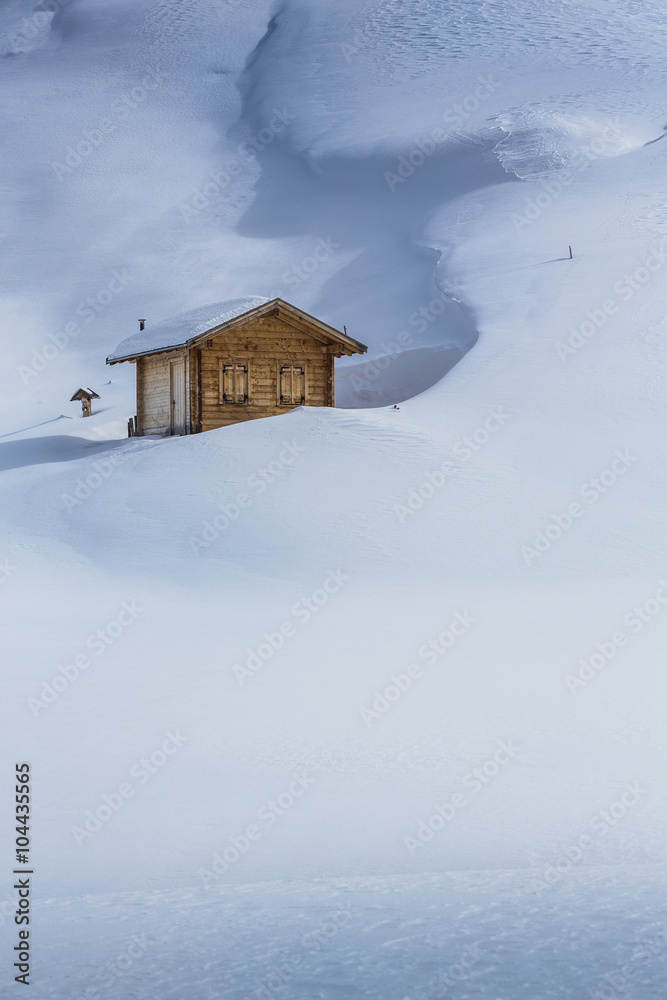 Tief verschneite Holzhütte in den Alpen