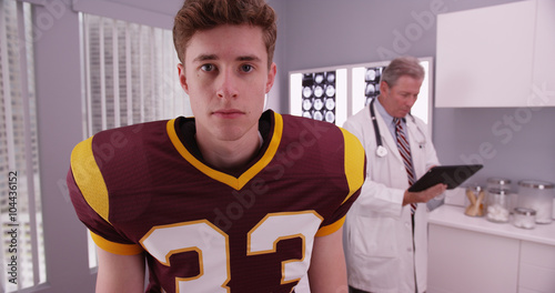 Handsome caucasian football athlete having doctor consultation