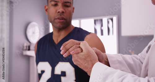 College basketball player with sports injury being examined by d