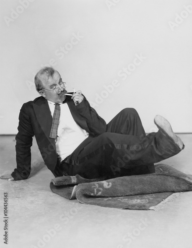 Man sitting on floor lighting cigarette  photo