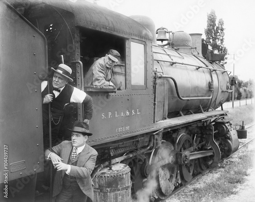 Three men waiting at a steam locomotive  photo