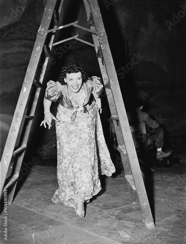 Woman walking under a step ladder with her fingers crossed  photo