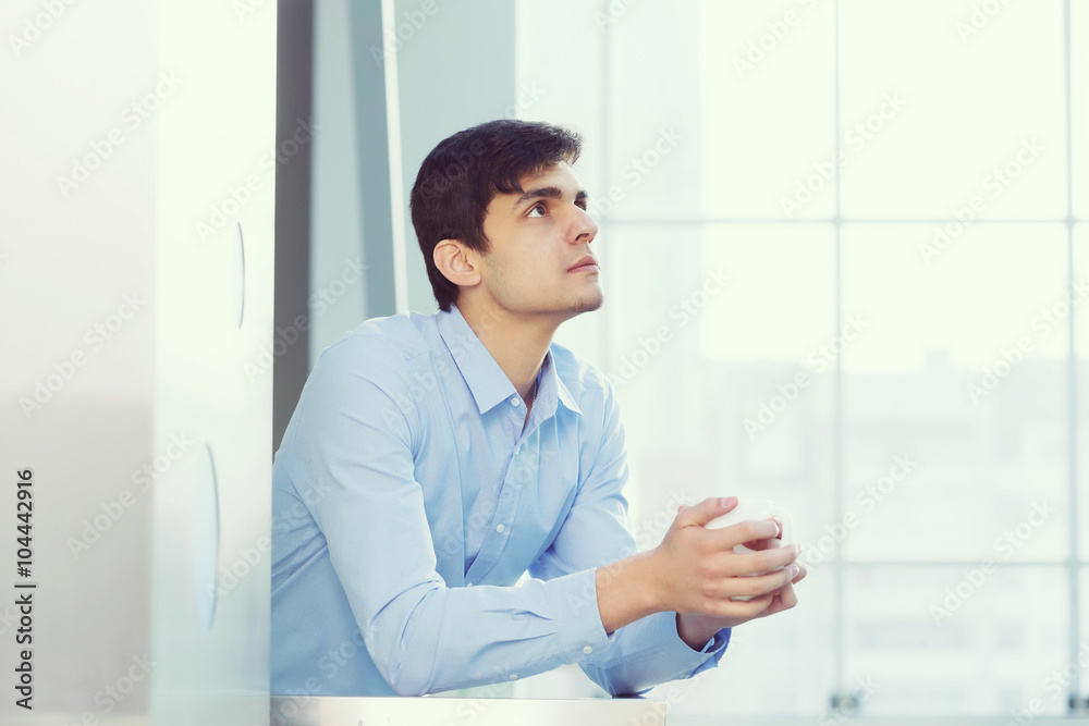 Businessman leaning on balcony railings