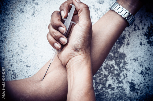 drug addict woman with syringe in action , digital gritty effect