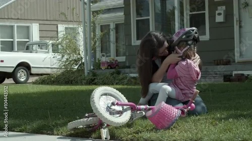 Mother conforting daughter after bike crash. photo