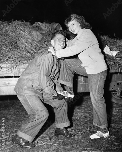 Portrait of a young man helping a young woman board a trailer  photo