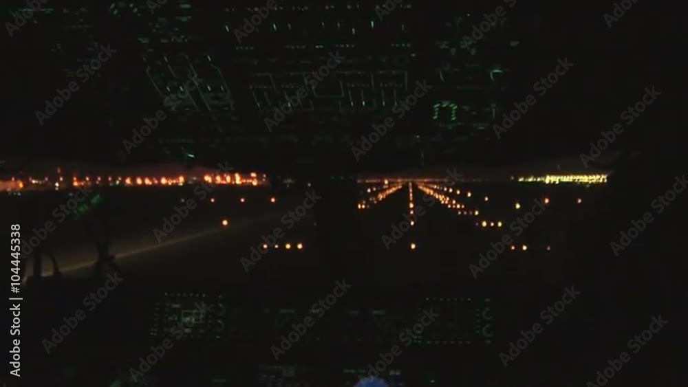 Point of view cockpit perspective of a commercial airplane taking off at night.