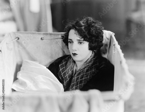 Woman sitting in a basket and daydreaming 