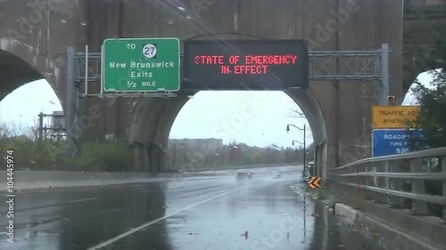 Waves whip the shore and roads show emergency signs during Hurricane Sandy. photo