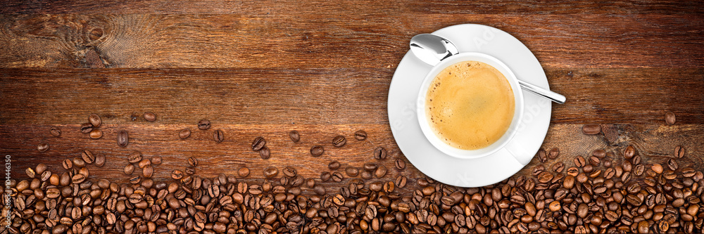 Obraz premium tło kawy z fasoli i filiżanki na rustykalne stare drewno dębowe