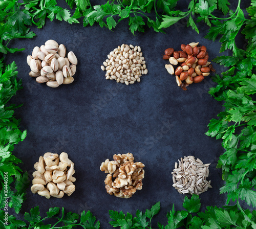 Wallpaper Mural Pistachios, pine nuts, peanuts, cashews, walnuts, and sesame seeds with parsley on grunge background. Flat lay. Torontodigital.ca